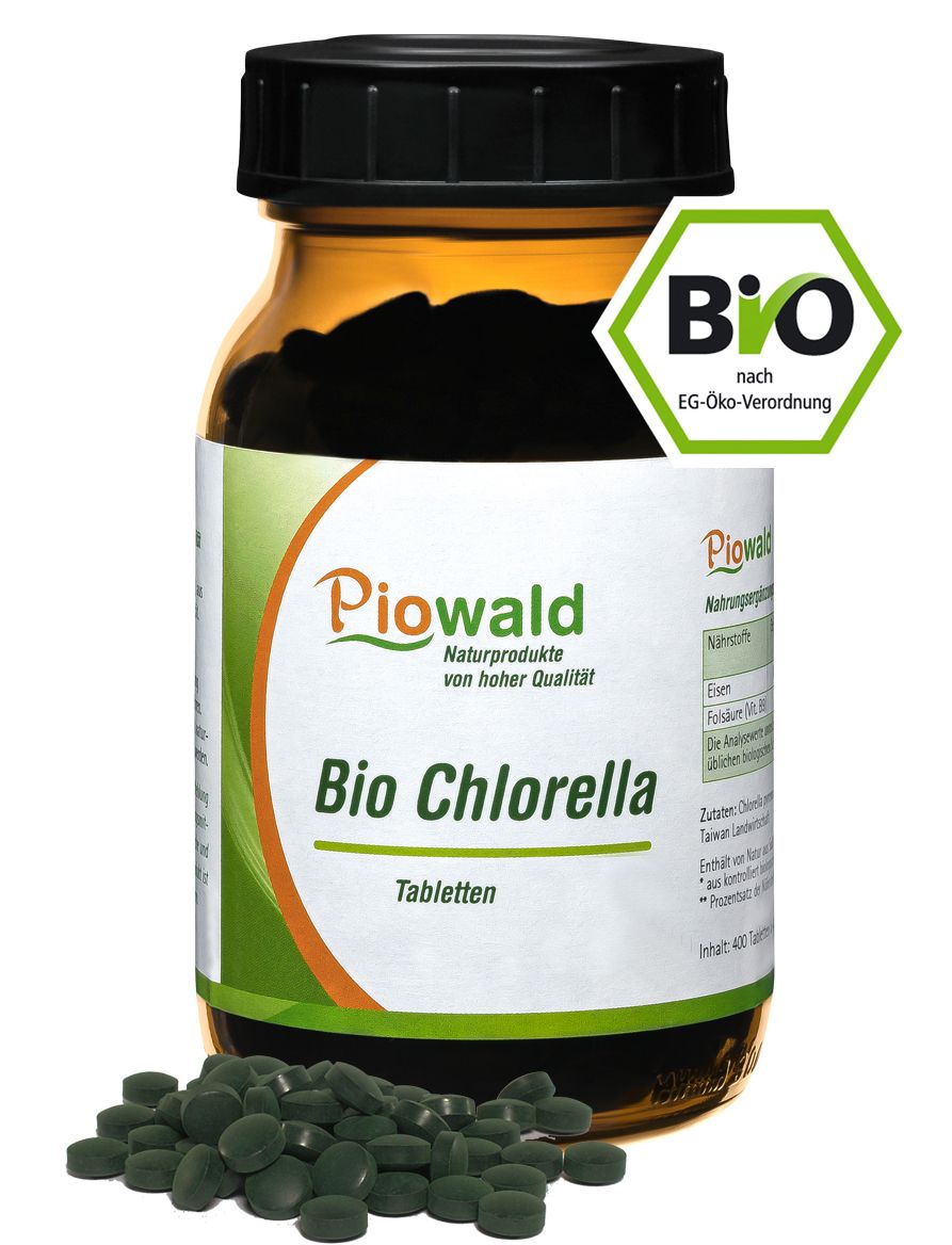 Braune Glasflasche mit schwarzen Deckel. Etikett mit "Piowald Bio Chlorella Tabletten". Grüne Tabletten daneben. Bio-Siegel.