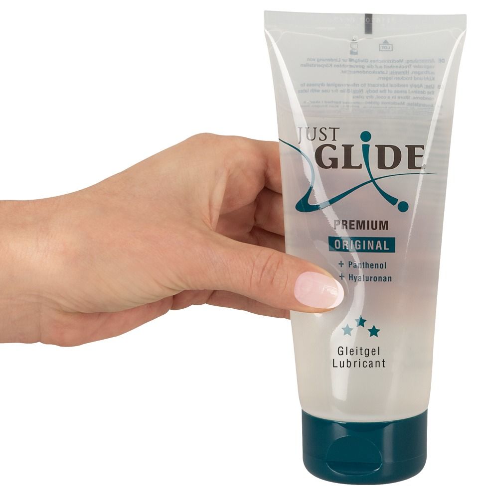 Hand hält Tube. Aufschrift: JUST GLIDE PREMIUM ORIGINAL. Enthält Panthenol und Hyaluronan. Gleitgel.