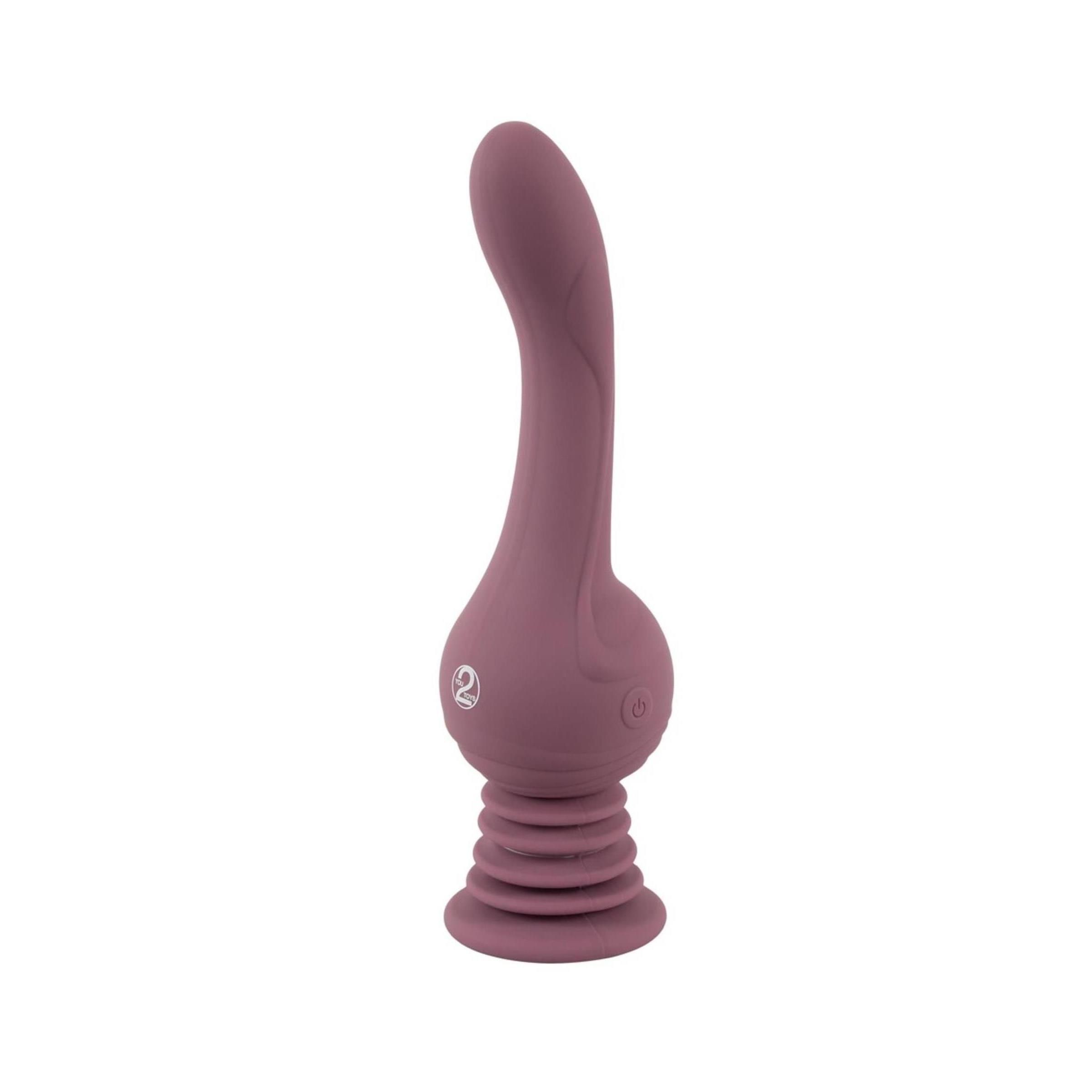 Lila Vibrator mit geriffelter Basis und geschwungener Form. Logo '2' auf dem Körper. Vertikale Ausrichtung, vor weißem Hintergrund.