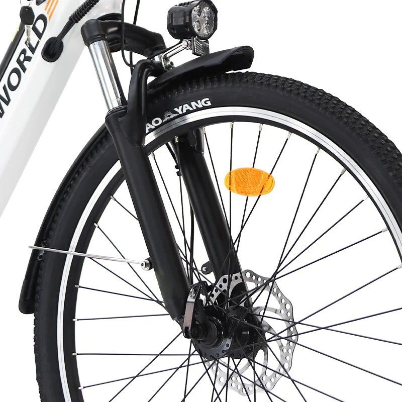 Nahaufnahme des Vorderrads eines weißen Elektrofahrrads. Schwarze Gabel, Scheinwerfer und Bremsscheibe.