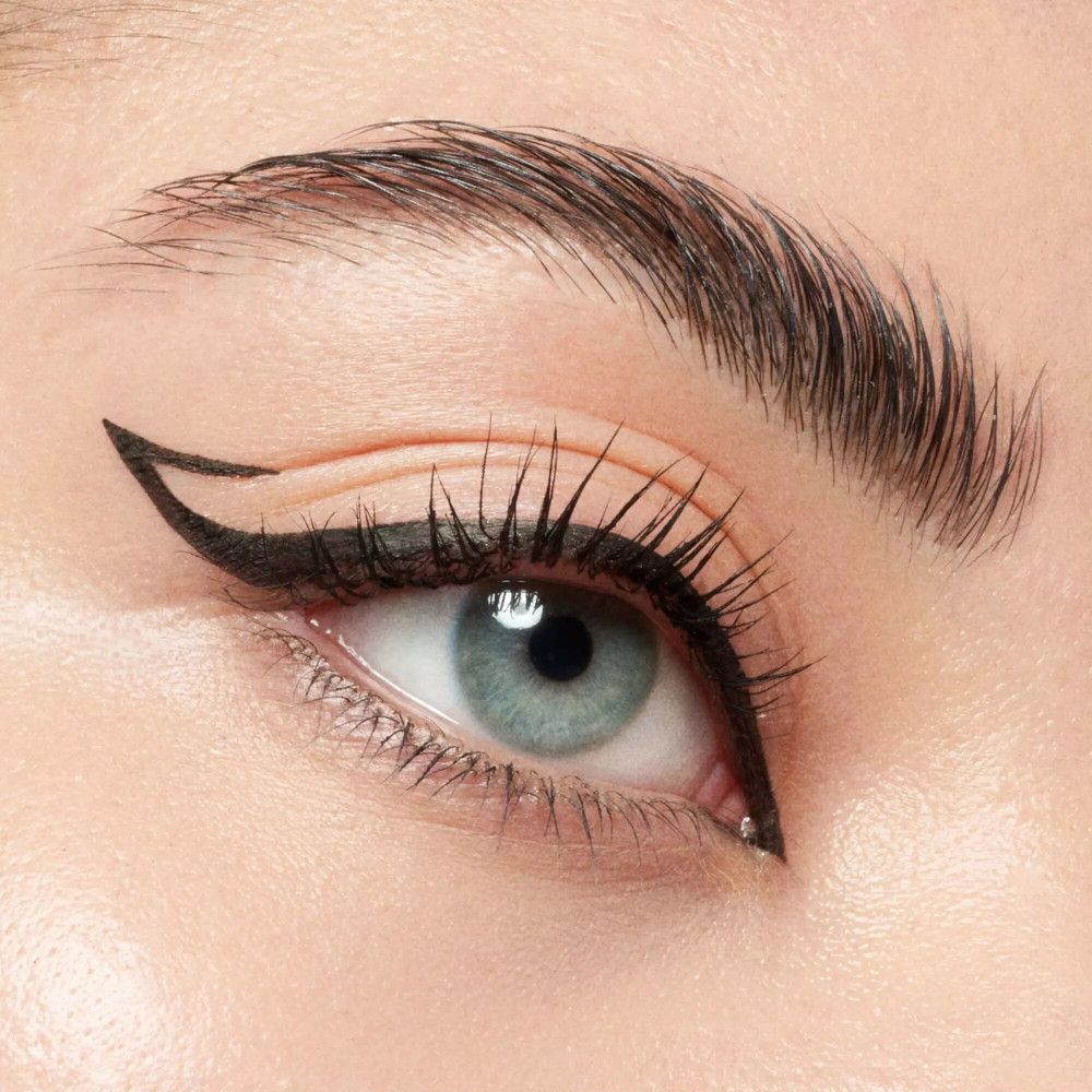Nahaufnahme eines Auges mit schwarzem Eyeliner. Der Eyeliner ist am äußeren Augenwinkel geflügelt.