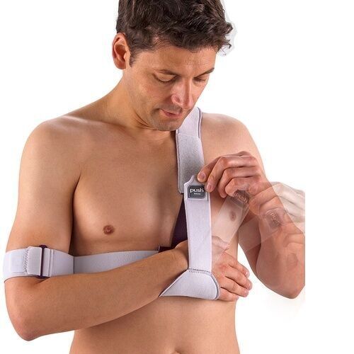 Mann fixiert Schulterbandage. Weißes Band mit Klettverschluss und Push-Logo. Arm in Bandage.