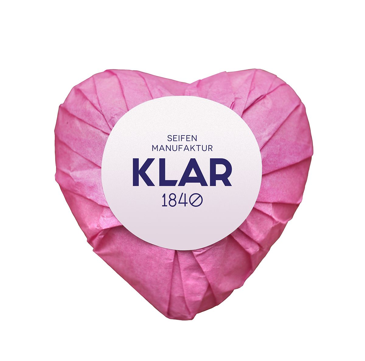 Herzförmige Seife in rosa Papier verpackt. Weißes Etikett mit "KLAR" und "1840".