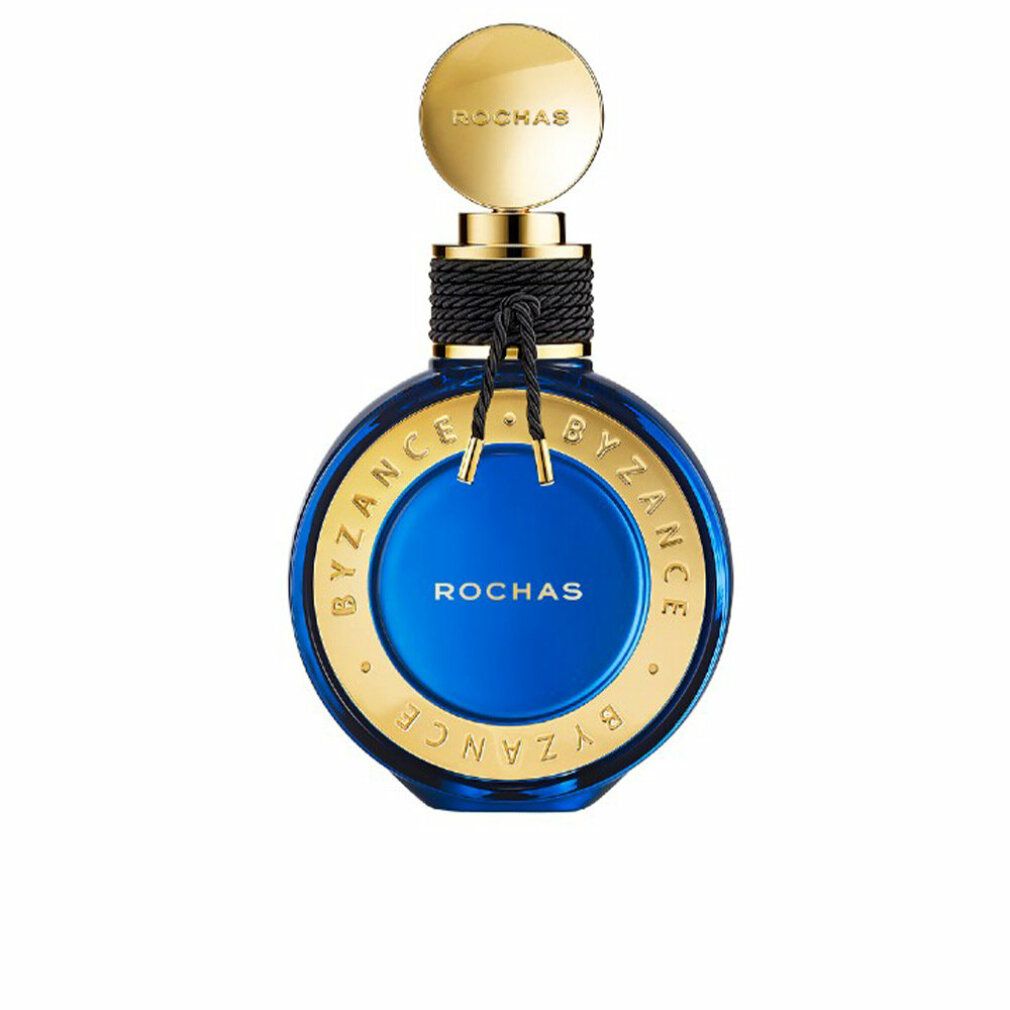 Blauer Flakon mit goldenen Akzenten. Aufschrift: Rochas Byzance. Schwarze Kordel um den Hals. Goldener Deckel.