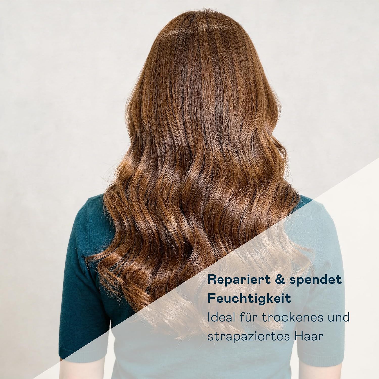 Rückansicht einer Frau mit langen, braunen, gewellten Haaren.