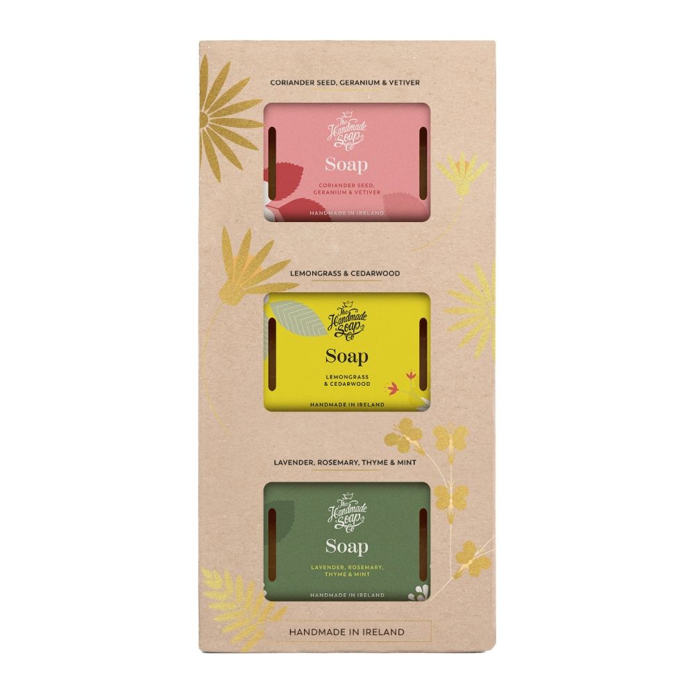 Geschenkset mit drei Seifenstücken in verschiedenen Farben. Jedes Stück hat eine andere Duftrichtung und ist in einer Pappverpackung mit floralen Elementen verpackt.