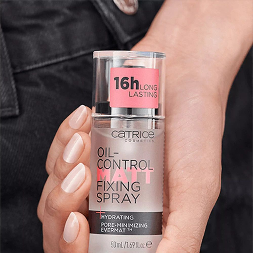 Catrice Fixierspray in Hand gehalten. Rosa Etikett mit Aufschrift '16h Long Lasting'. Produktbezeichnung sichtbar.