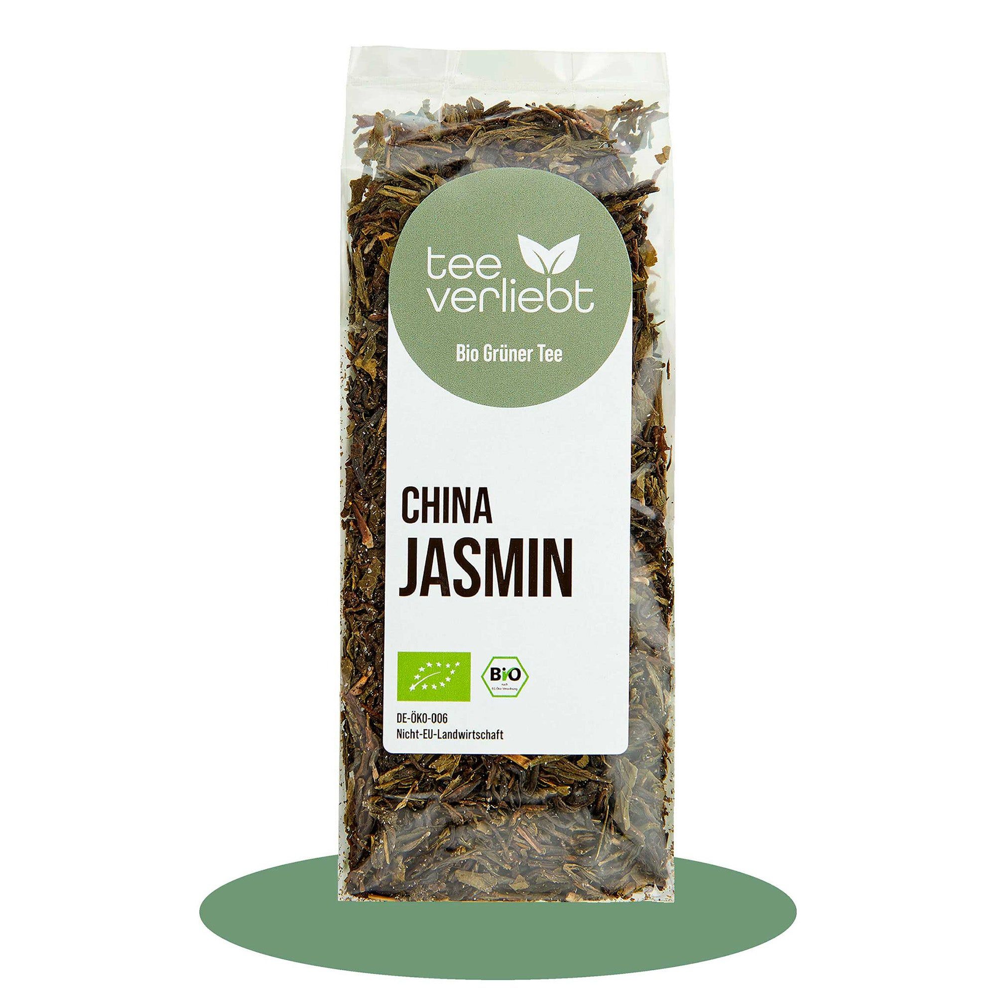 Transparente Verpackung mit losem Grüntee. Aufkleber mit "tee verliebt", "China Jasmin" und Bio-Siegel.