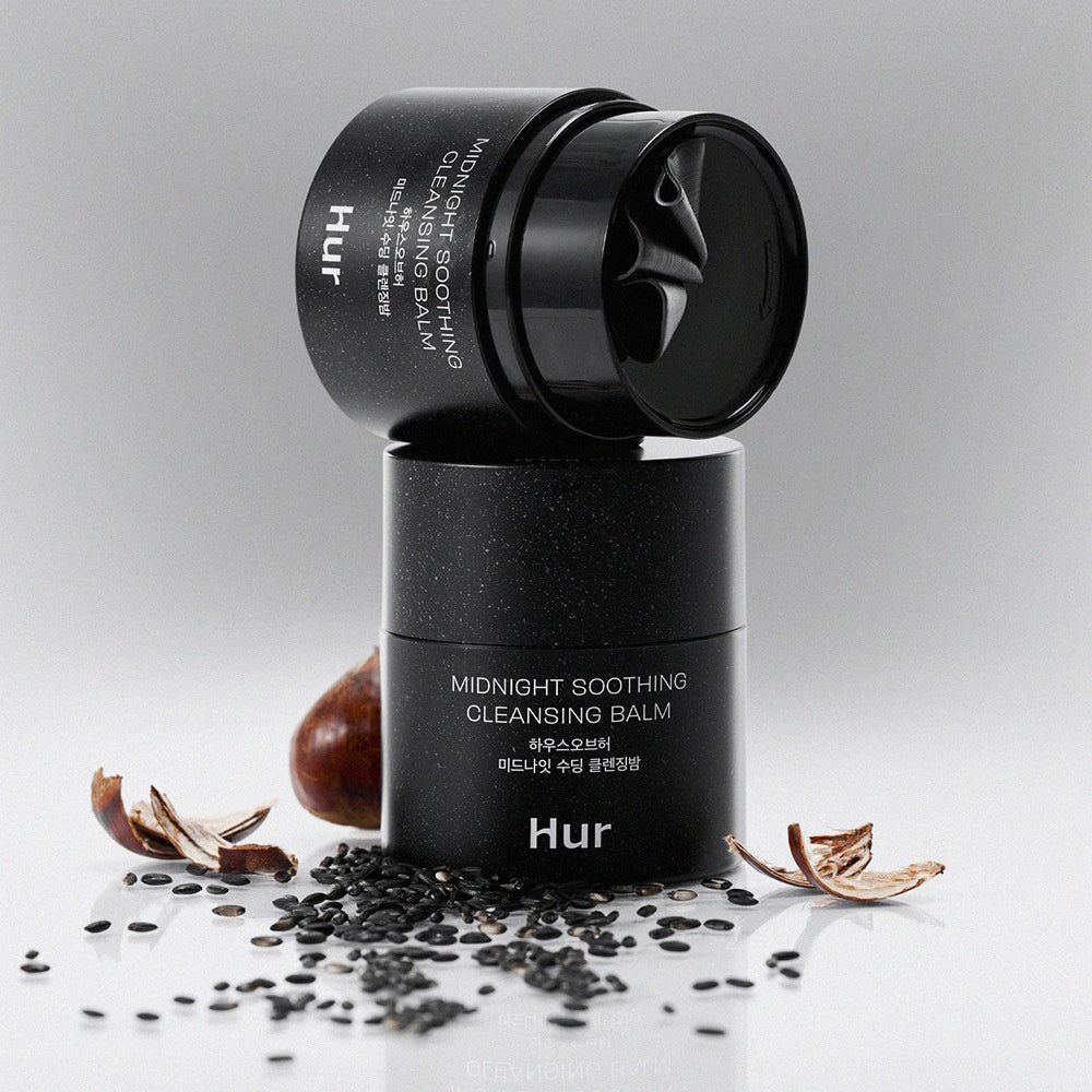 Zwei schwarze Tiegel, einer auf dem anderen. Aufschrift: Midnight Soothing Cleansing Balm. Marke: Hur. Hintergrund weiß.