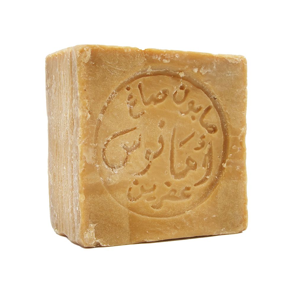 Ein einzelnes Seifenstück, quadratisch, mit arabischer Schrift in einem Kreis. Hellbraune Farbe.