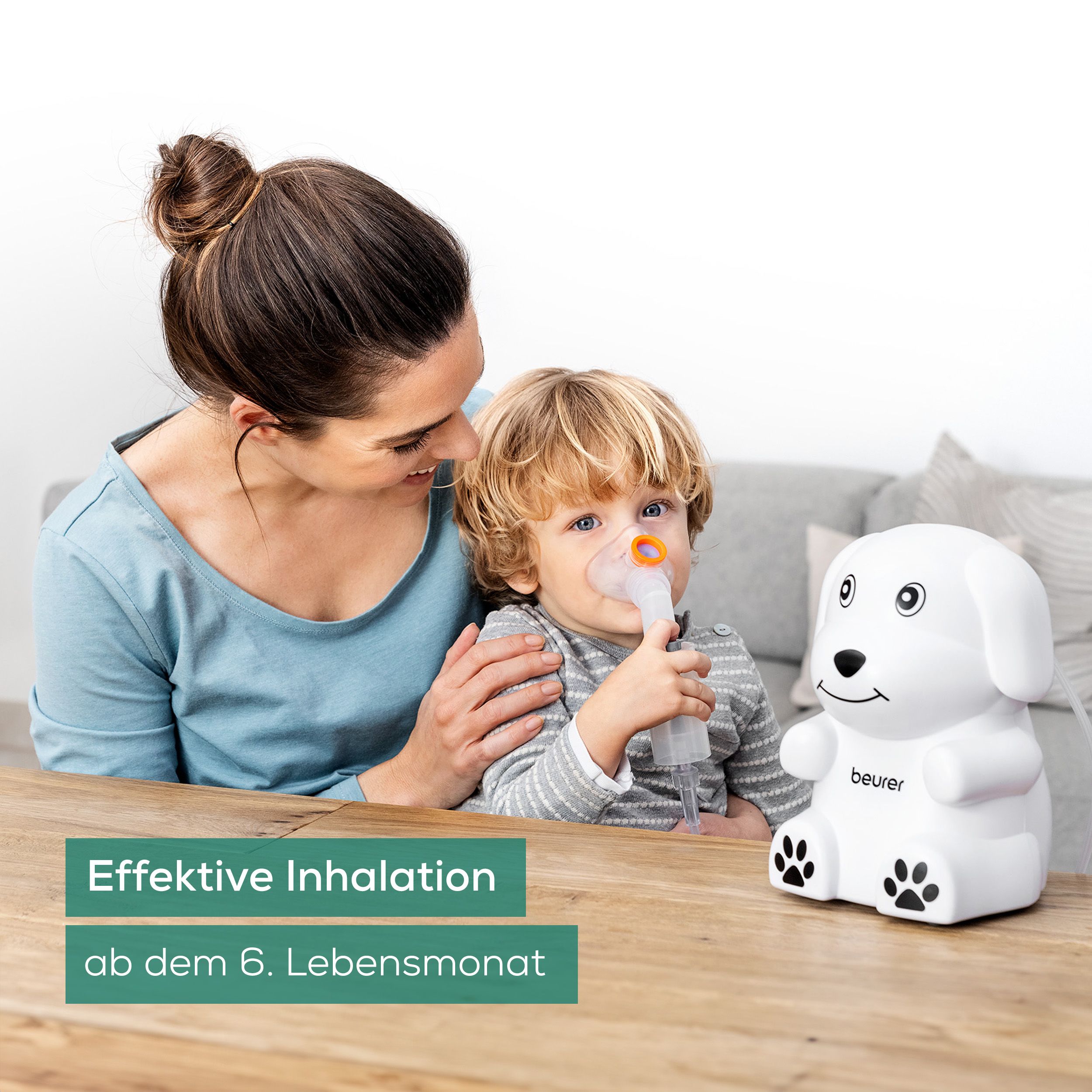 Mutter und Kind mit Inhalationsmaske. Weißer Inhalator in Hundeform. Orange Maske. Text: Effektive Inhalation ab dem 6. Lebensmonat.