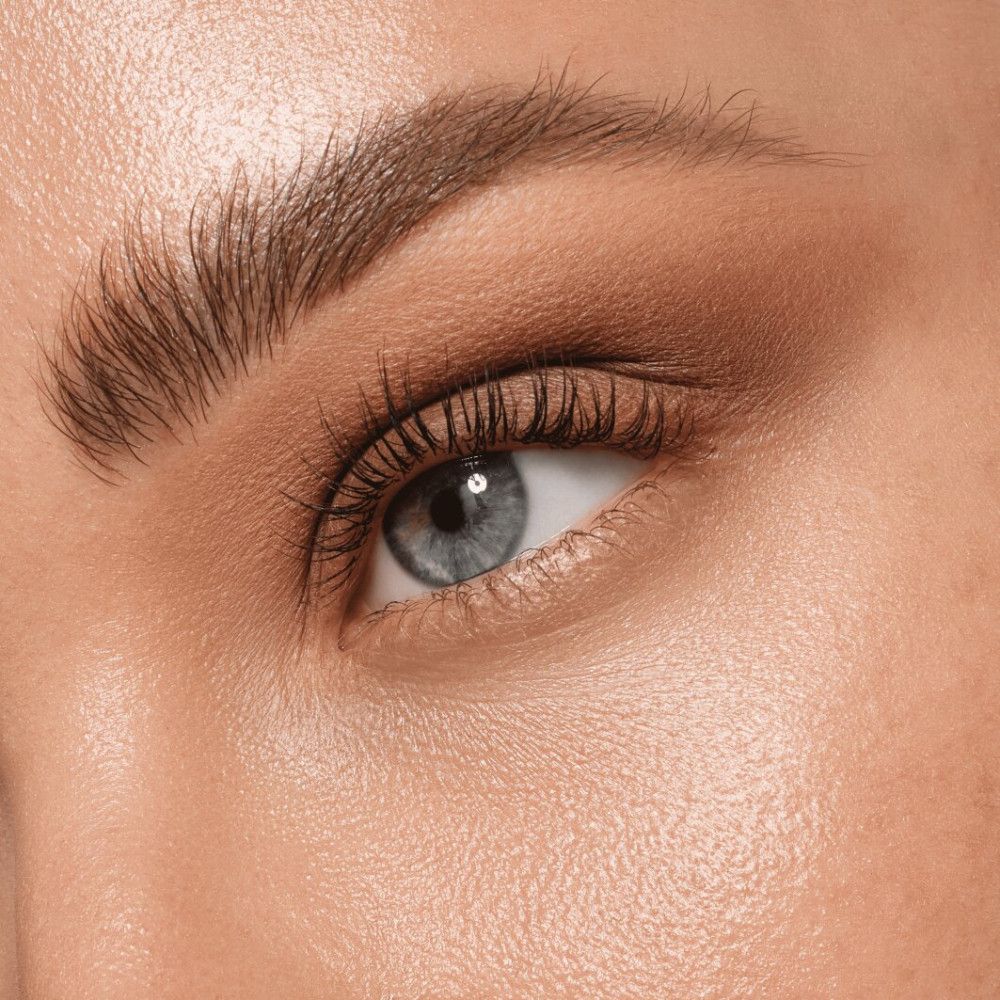 Nahaufnahme eines Auges mit Lidschatten. Blaues Auge, braune Augenbrauen.