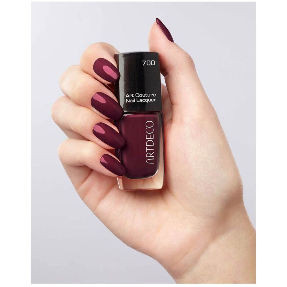 Nagellackflasche, gehalten in einer Hand. Lackfarbe: Dunkelrot. Aufschrift: Artdeco, Art Couture Nail Lacquer.