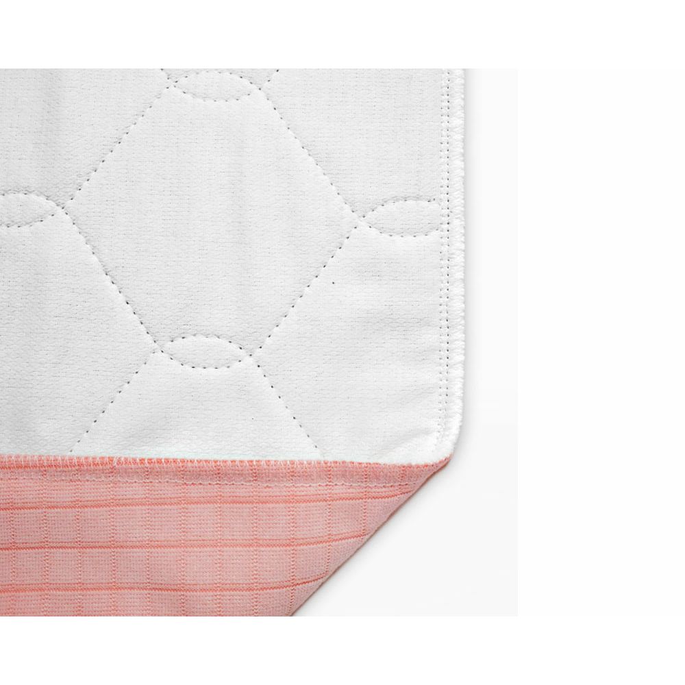 Nahaufnahme der Mehrfach-Bettauflage. Weiße, gesteppte Oberfläche. Unterseite mit rosa Streifen.