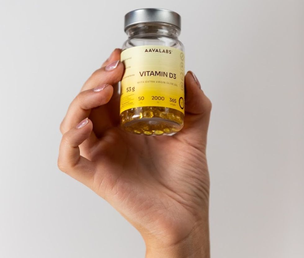Hand hält eine Flasche Aavalabs Vitamin D3 mit 2000 IE.