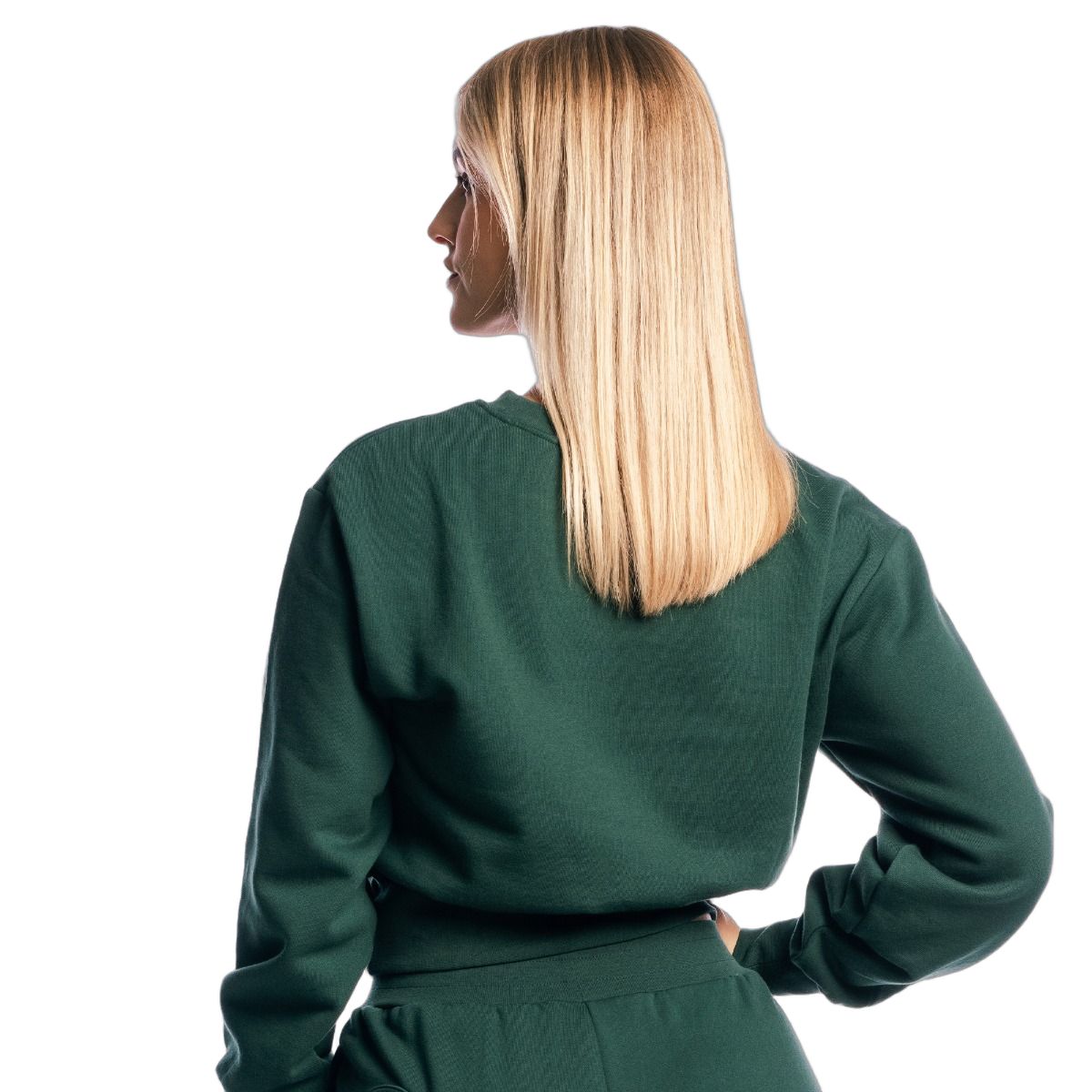 Rückansicht einer Frau im grünen Pullover cropped Langarm Forest. Langes blondes Haar.
