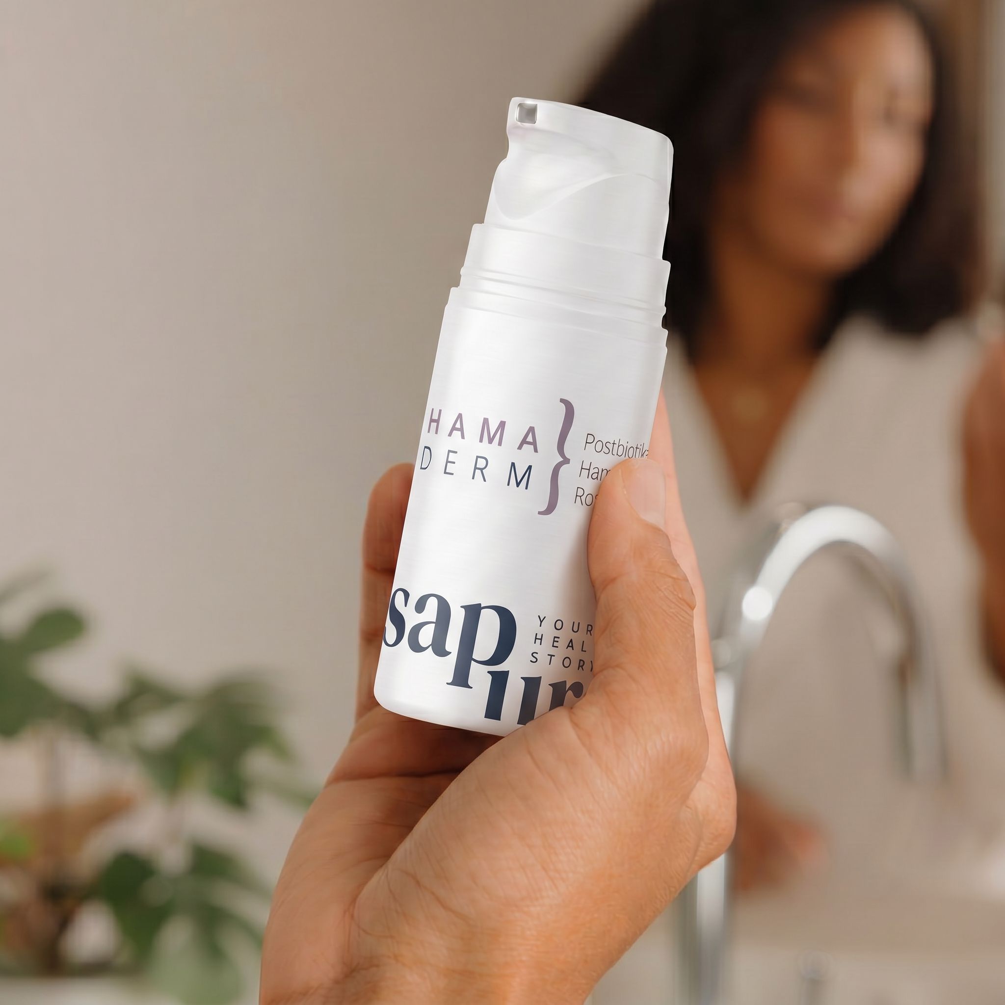 Weiße Flasche mit Pumpspender in einer Hand, im Badezimmer.