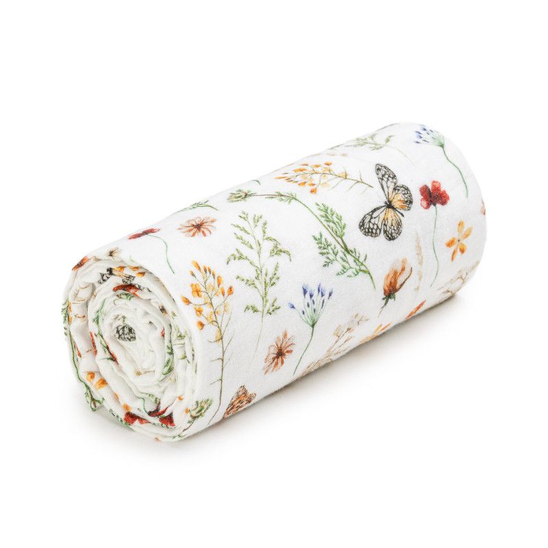 Gerolltes Musselinbadetuch mit Blumen- und Schmetterlingsmuster. Weißer Stoff mit bunten floralen Motiven.