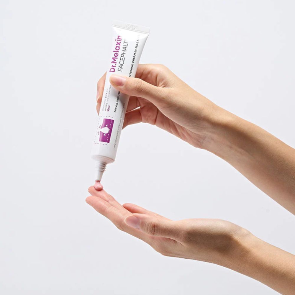 Eine Hand hält eine Tube Dr. Melaxin Facephalt Gesichtscreme, während eine kleine Menge auf die andere Handfläche aufgetragen wird.