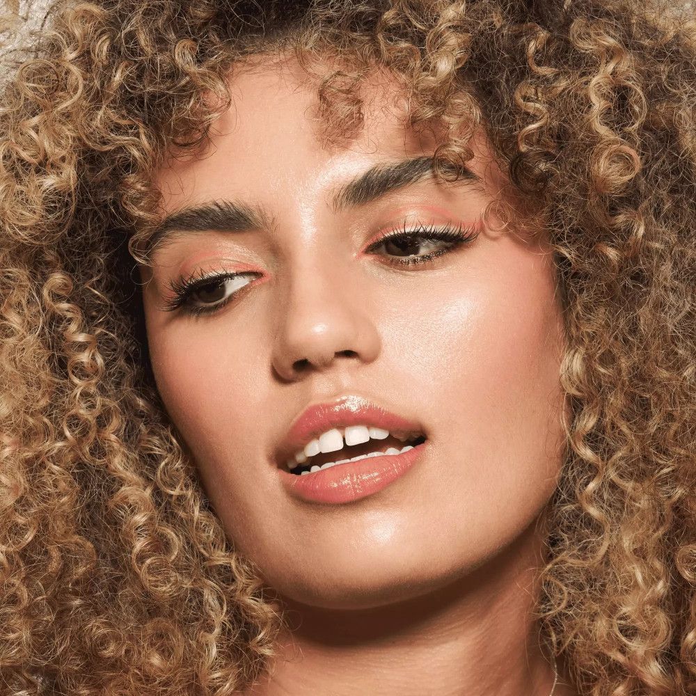 Frau mit lockigem Haar, Kajal auf den Augen.