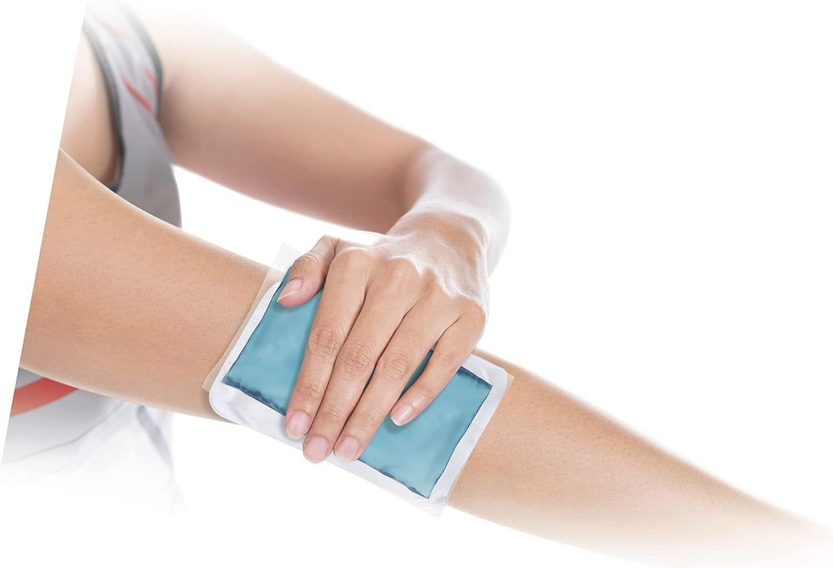 Person hält blaue Kälte- und Wärmekompresse am Arm. Produkt ist rechteckig und in einer weißen Hülle.