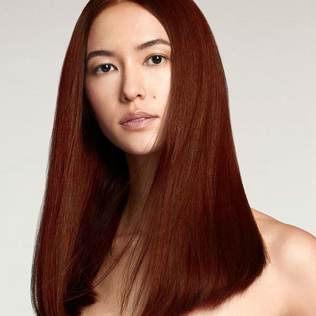 Porträt einer Frau mit langen, braunen Haaren. Sie blickt direkt in die Kamera. Die Haare sind glatt und fallen über die Schultern.