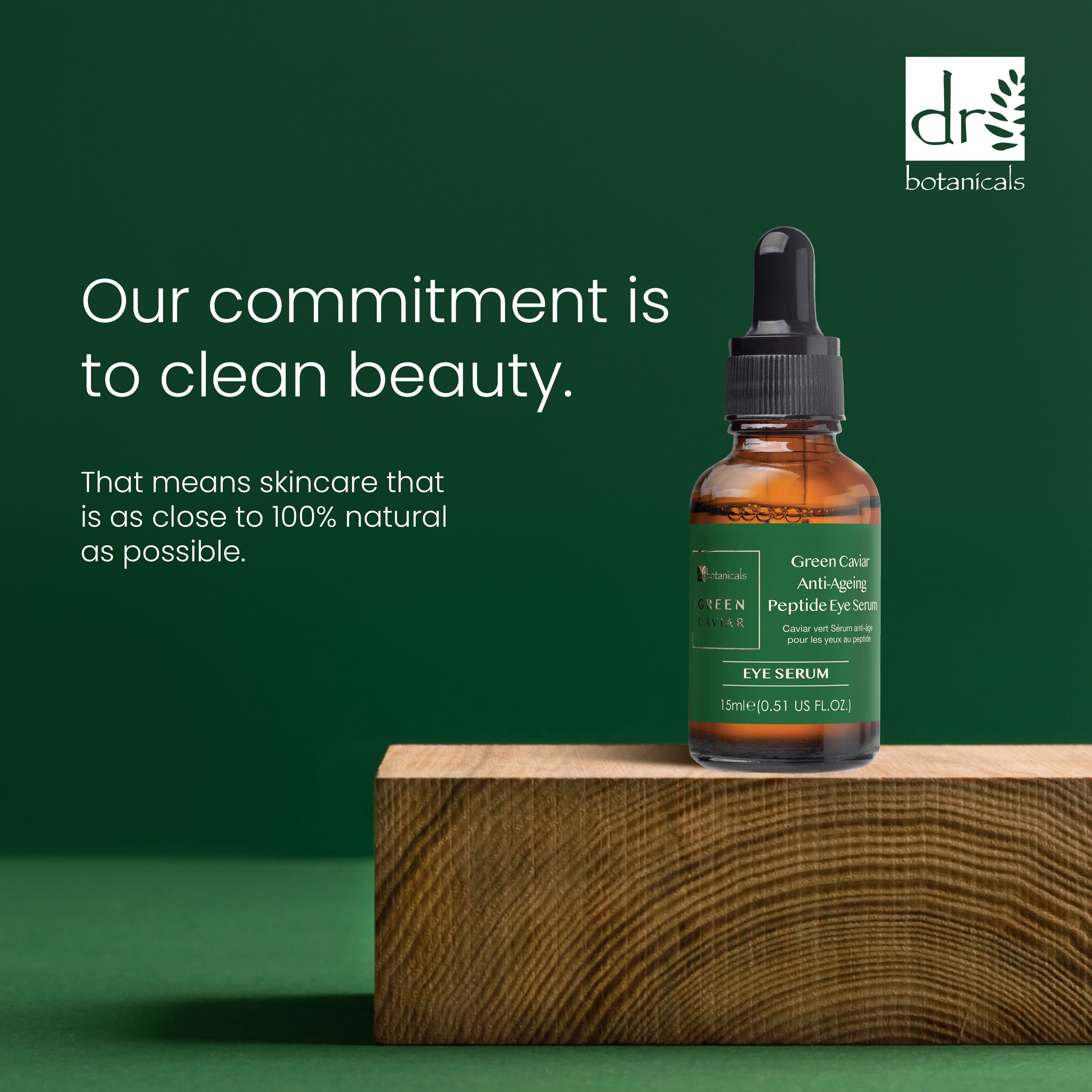 Braune Glasflasche mit schwarzer Pipette auf Holzblock. Text: Our commitment is to clean beauty.