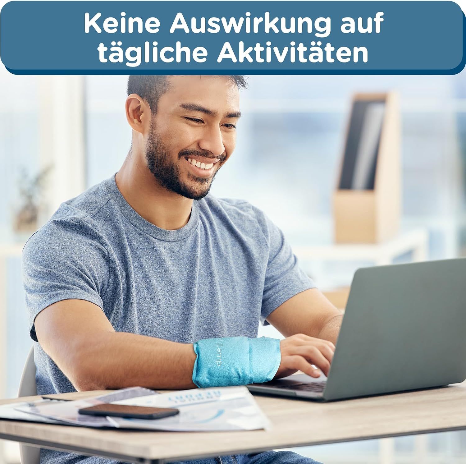 Ein Mann arbeitet am Laptop, trägt eine blaue Handgelenkbandage.