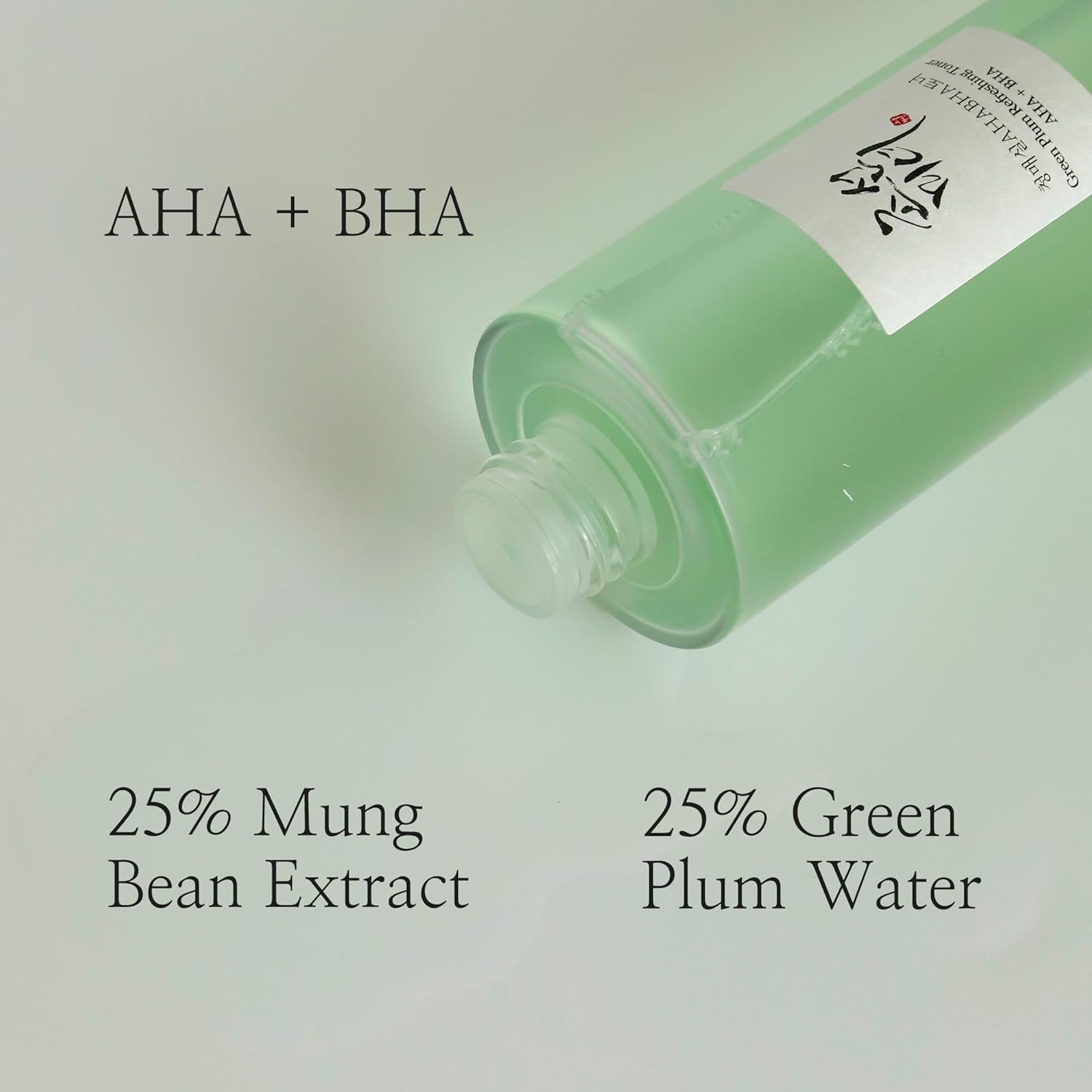 Toner-Flasche, schräg von unten. Aufschrift: AHA + BHA. Text: 25% Mungobohnenextrakt, 25% Grünes Pflaumenwasser.