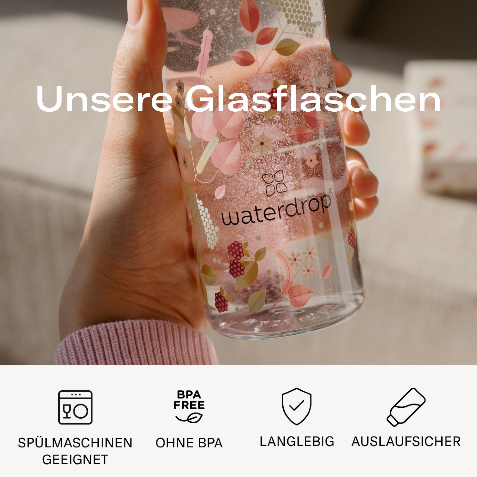 Hand hält eine Glasflasche mit floralem Muster. Text: waterdrop®, Spülmaschinen geeignet, BPA-frei, langlebig, auslaufsicher.