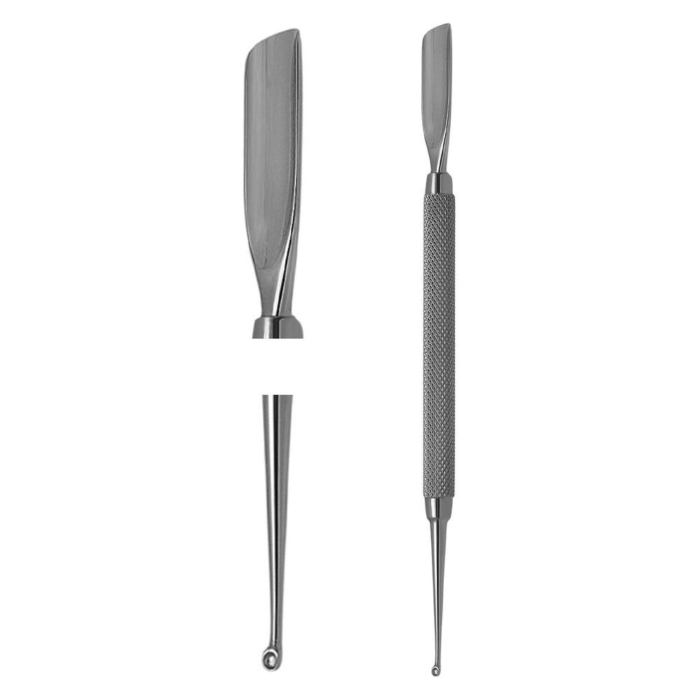 Nagelhautschieber und Komedonenheber aus Metall. Ein Ende spatelförmig, das andere spitz mit kleiner Öffnung. Geriffelter Griff. Nahaufnahme.