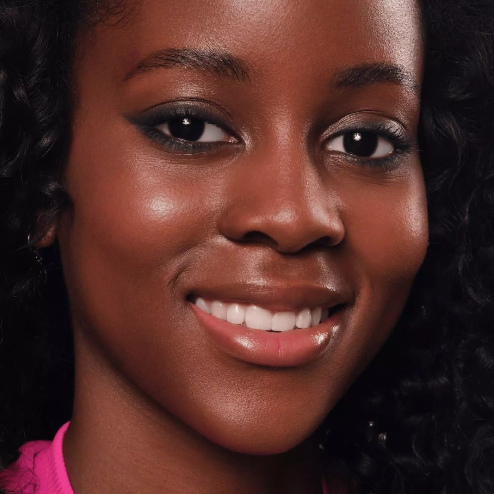 Nahaufnahme eines Gesichts. Augen mit Eyeliner. Offener Mund. Dunkle Haut.