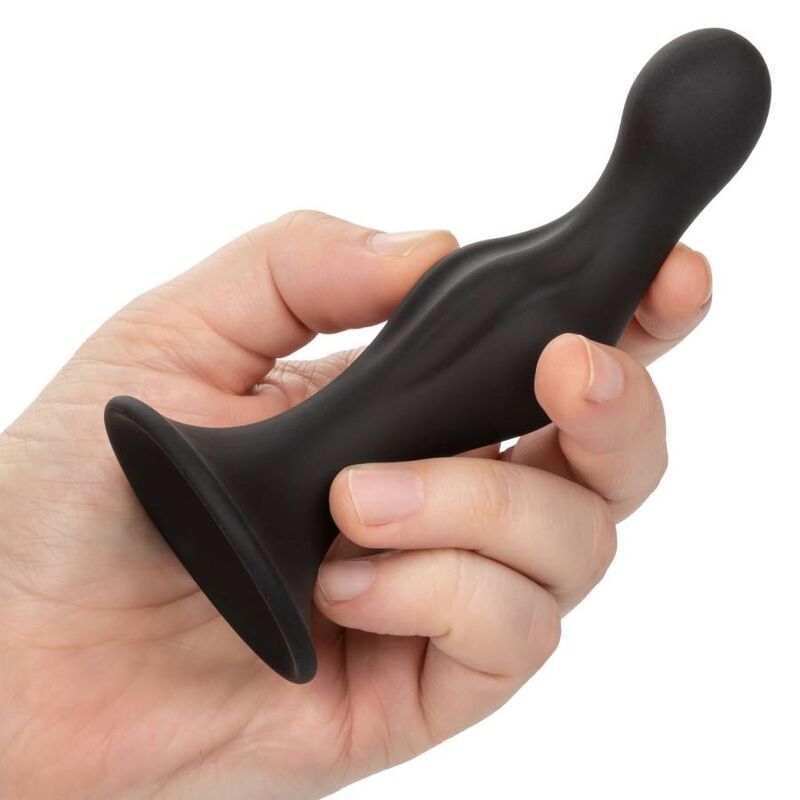 Eine Hand hält einen schwarzen Anal-Stöpsel. Der Stöpsel hat eine geschwungene Form.