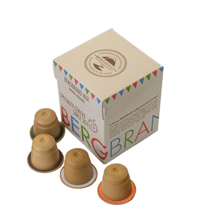 Kaffeekapseln und Verpackung. Kapseln mit farbigen Rändern. Verpackung mit Logo und Text.