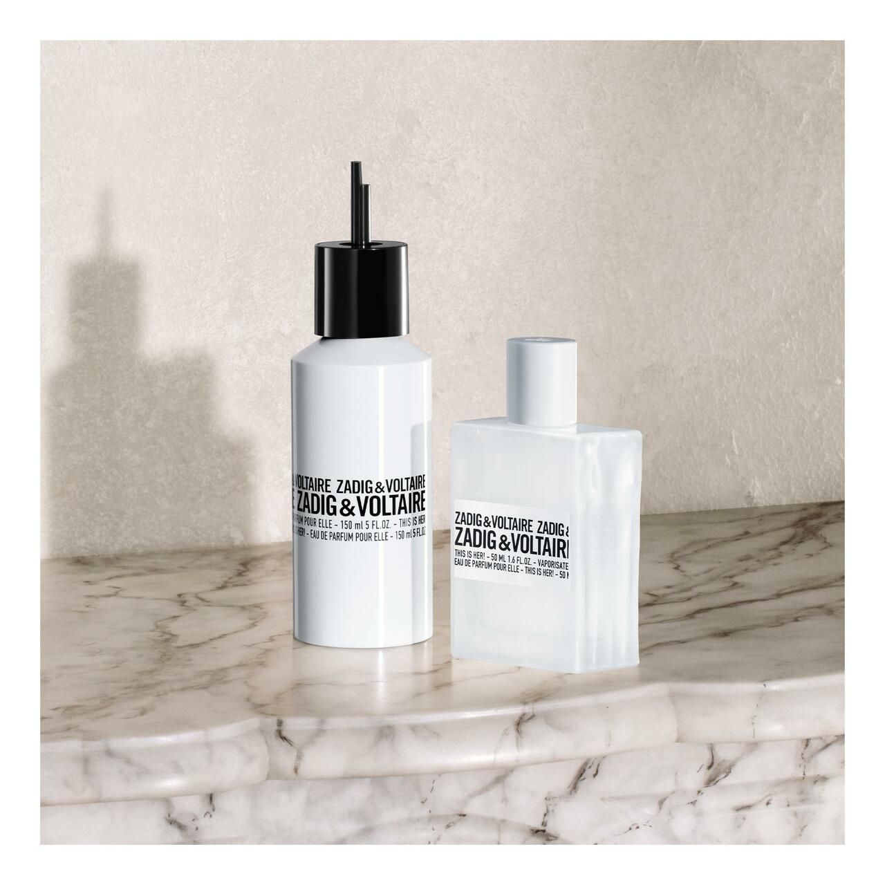 Zwei weiße Flakons mit schwarzen und weißen Verschlüssen. Auf Marmoroberfläche.