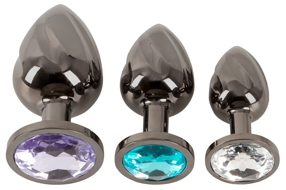 Drei Metall-Analplugs mit spiralförmiger Oberfläche und verschiedenen Schmucksteinen.