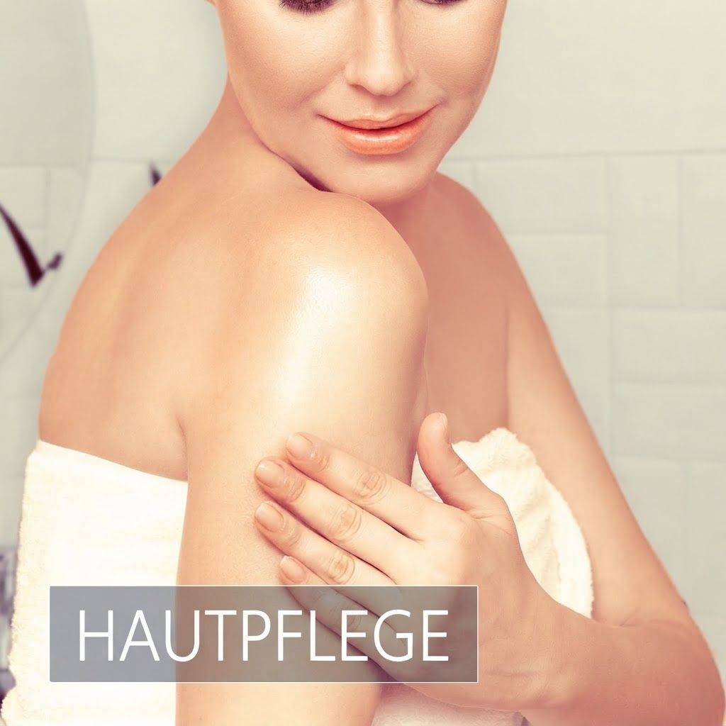 Frau mit Handtuch, die ihre Schulter eincremt.