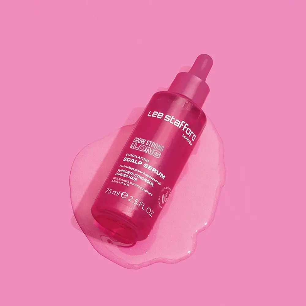 Rosa Pipettenflasche des Lee Stafford Grow Strong & Long Stimulating Scalp Serums auf rosa Untergrund.