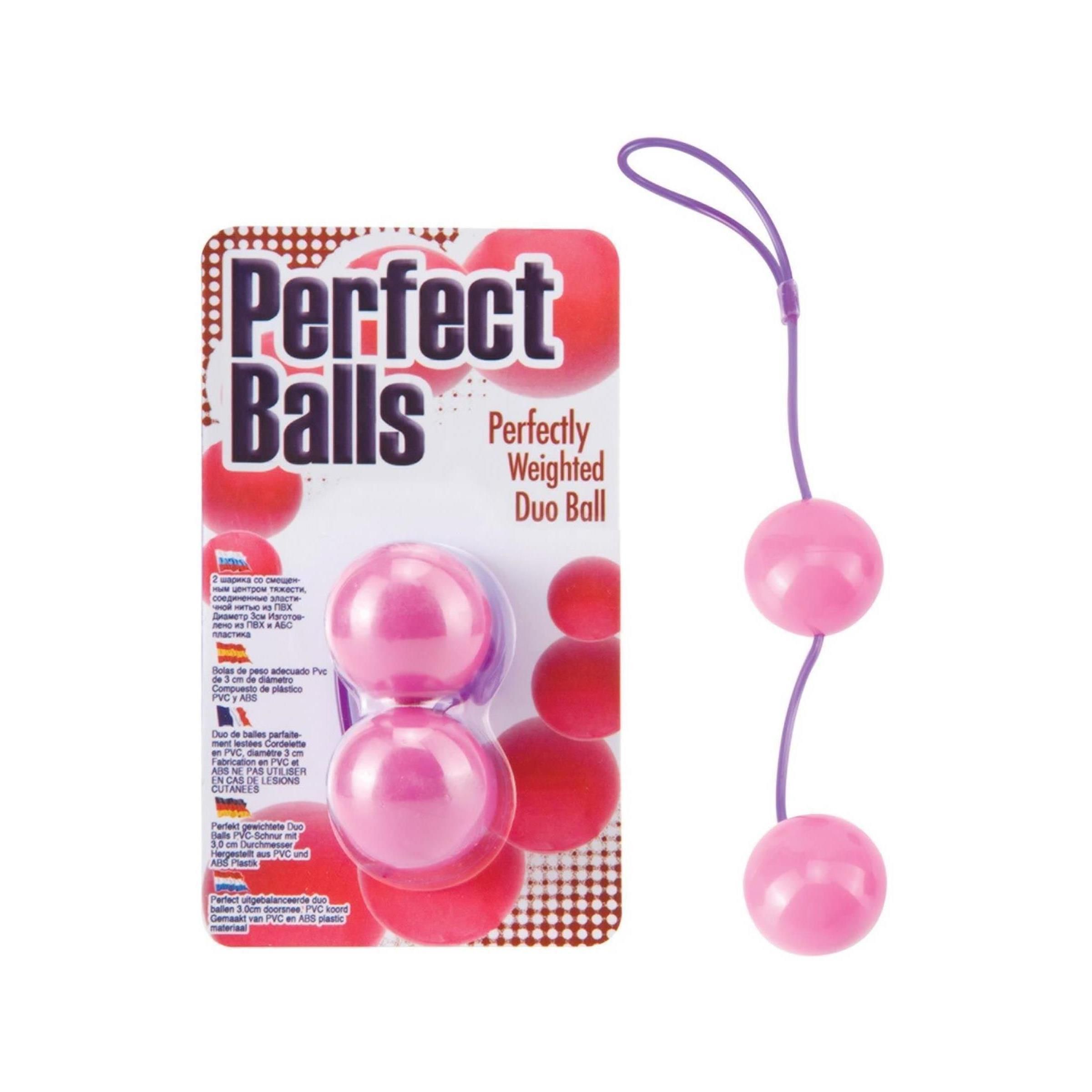 Zwei rosafarbene Kugeln mit lila Schnur. Auf der Verpackung steht "Perfect Balls" und "Perfectly Weighted Duo Ball".