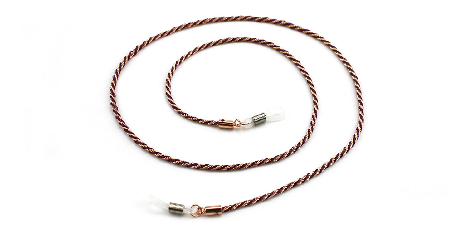 Brillenkette mit braun-rotem Seil und Metallenden. Die Kette ist gewunden und hat transparente Silikon-Schlaufen.
