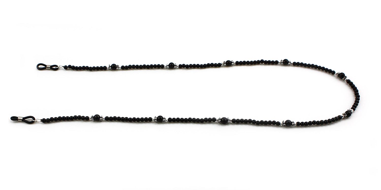 Brillenkette mit schwarzen Perlen und silberfarbenen Elementen. Die Kette ist in einer geschwungenen Form angeordnet.