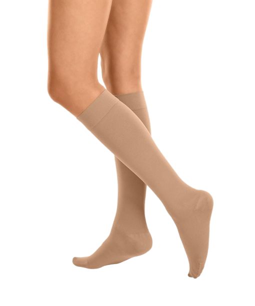 Beige Kompressions-Kniestrümpfe mit offener Zehenpartie, die bis zum Knie reichen.