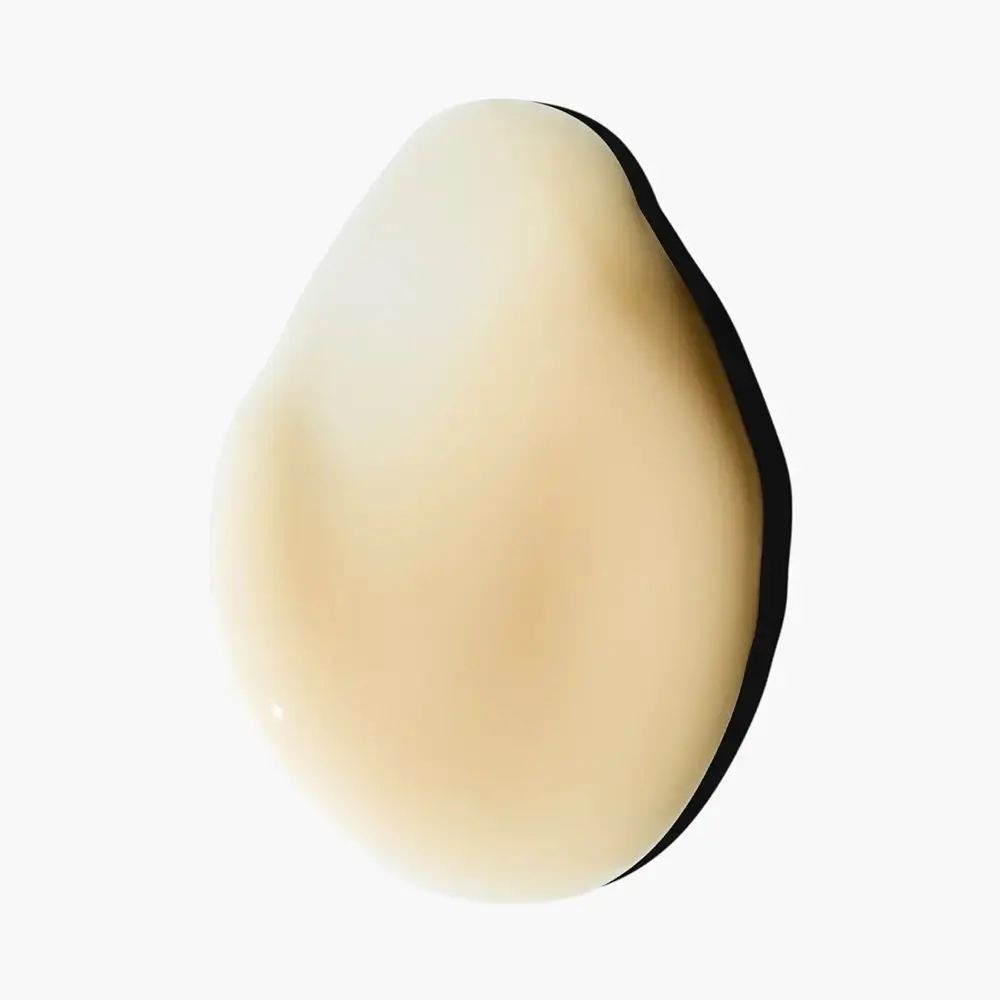 Tropfenförmiger, cremefarbener Flüssigkeitstropfen mit dunklem Schatten.