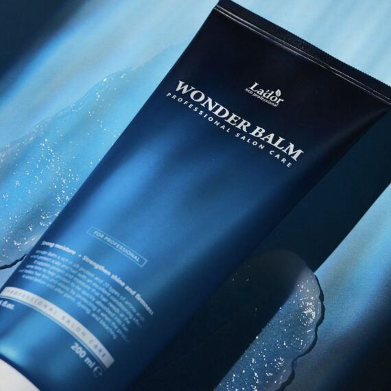 Blaue Tube mit Aufschrift: Lador Wonder Balm, Professional Salon Care. Produkt liegt auf blauer Oberfläche.