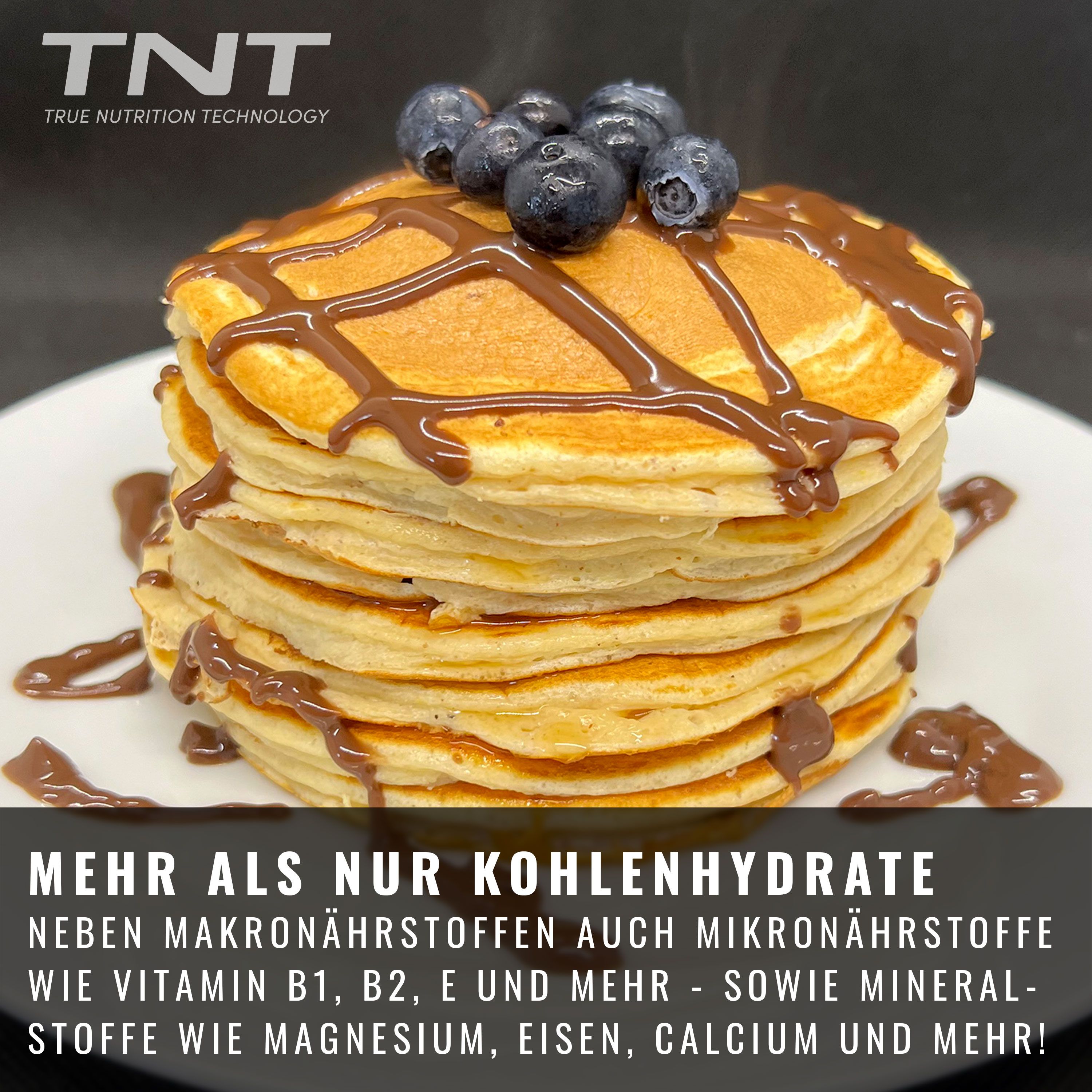 Teller mit gestapelten Pancakes, belegt mit Schokoladensauce und Blaubeeren. Dose TNT Protein Pancakes im Hintergrund.