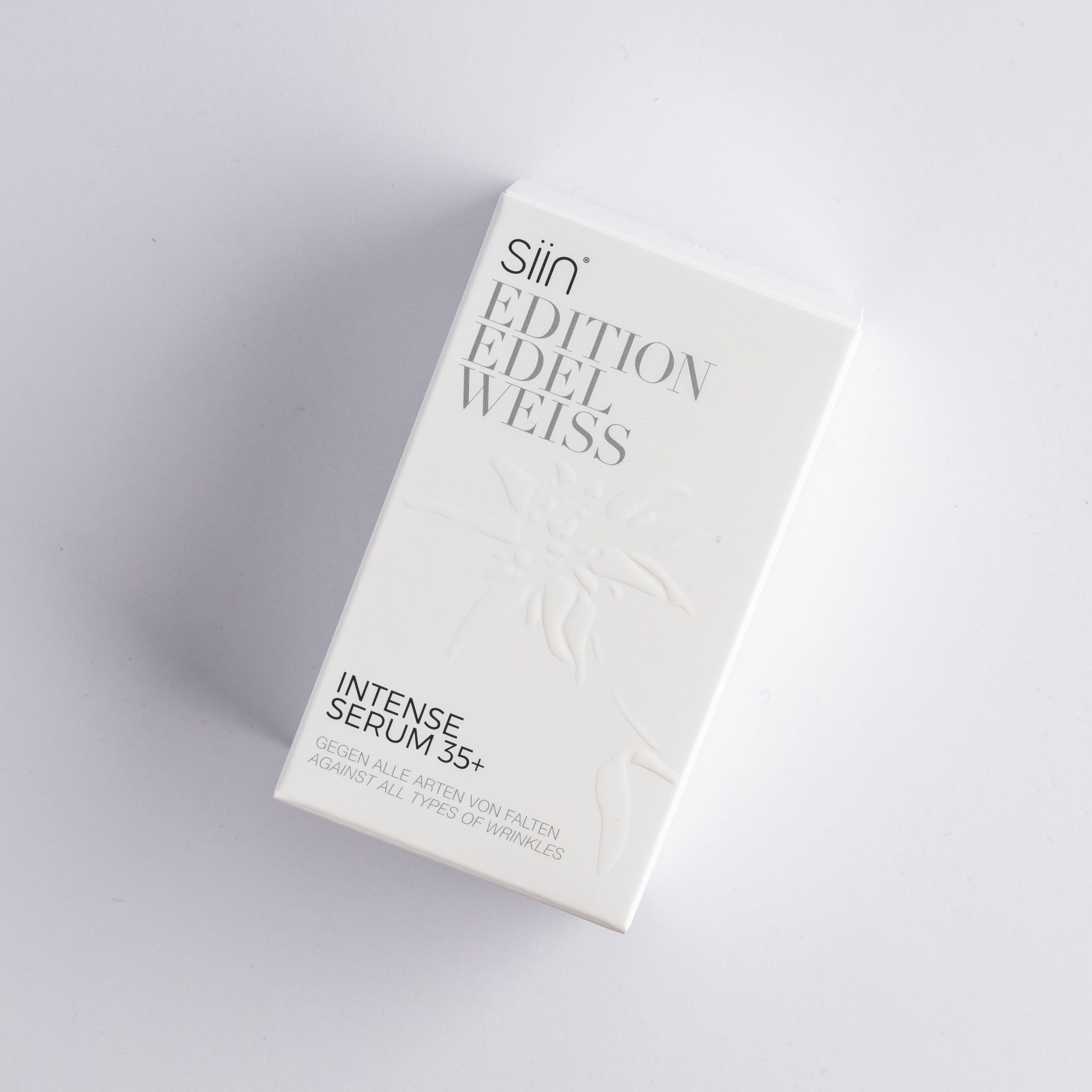 Weiße Schachtel mit Produktnamen und Text. Geprägtes Edelweiß-Design. Text: Intense Serum 35+ gegen Falten.