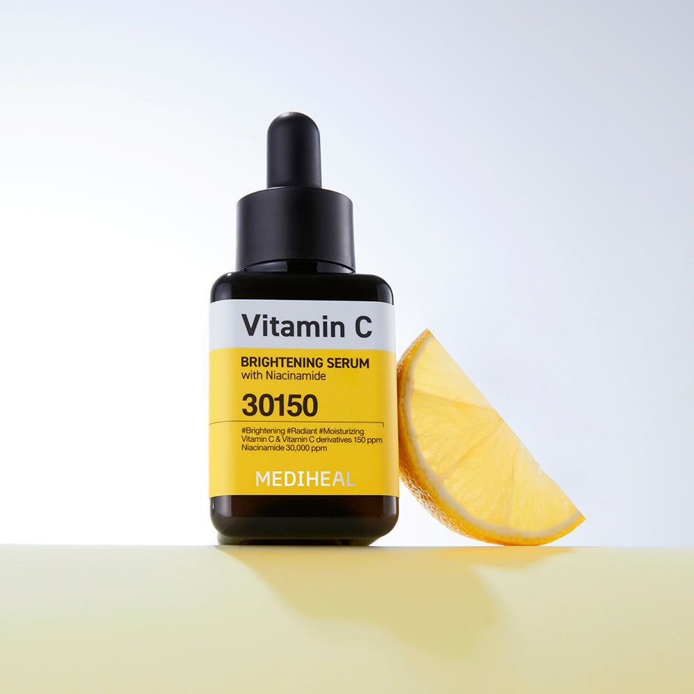 Serumflasche mit schwarzem Deckel. Gelbes Etikett mit Text: Vitamin C, 30150. Zitronenscheibe.
