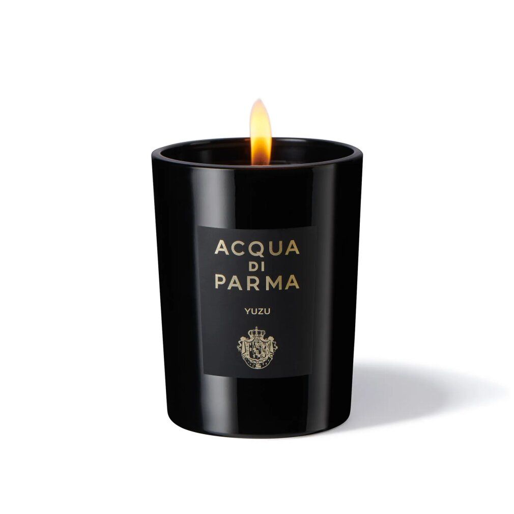 Schwarze Kerze mit Flamme. Etikett: ACQUA DI PARMA, YUZU. Logo. Zylindrische Form. Brennende Kerze.