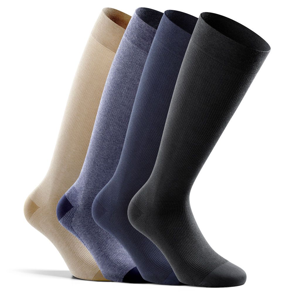 Vier Kompressions-Kniestrümpfe in Beige, Blau, Dunkelblau und Schwarz. Blick von der Seite, leicht schräg.