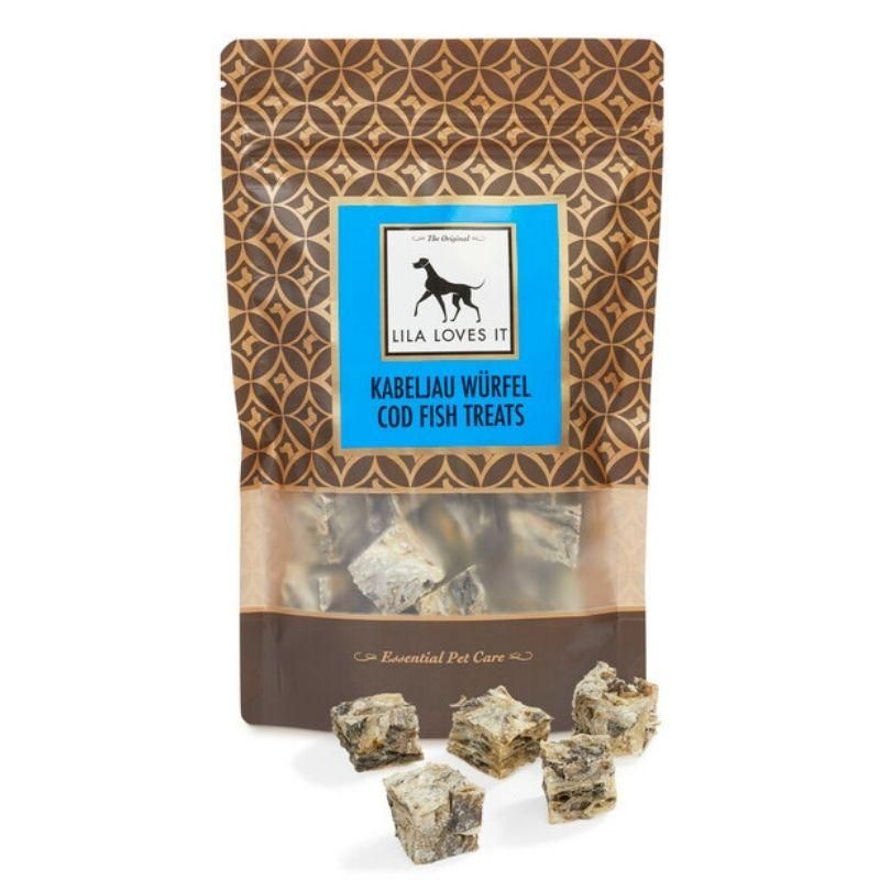 Beutel mit Kabeljau Würfeln. Blaue Aufschrift mit Logo und Text: LILA LOVES IT, Kabeljau Würfel, Cod Fish Treats. Einige Würfel liegen davor.